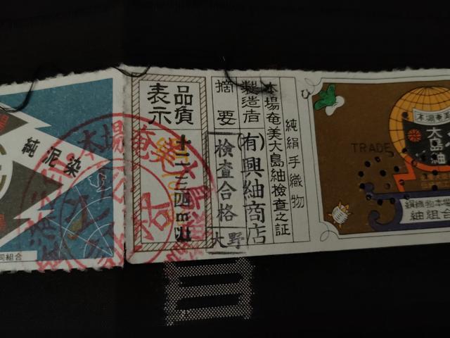 平和屋着物●本場大島紬　純泥染　カタス9マルキ　地空き　色紙重ね文　黒地　興紬商店謹製　証紙付き　正絹　逸品　未使用　AABG6601cs